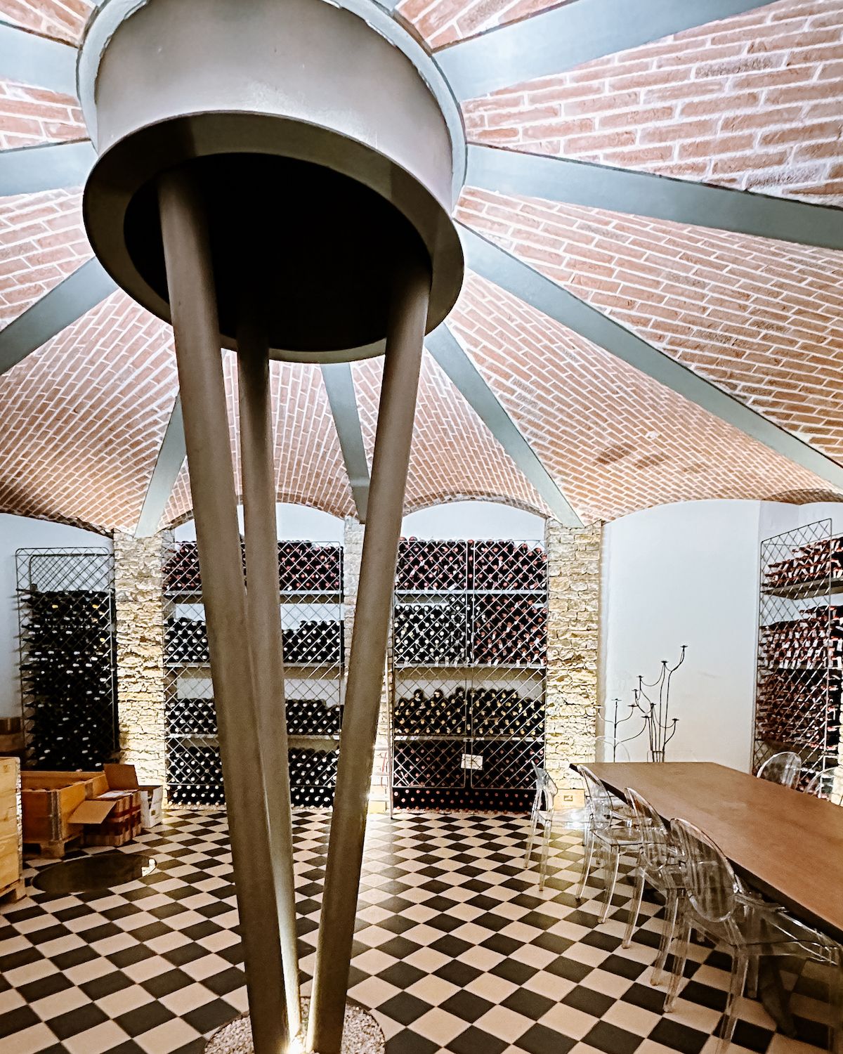 Wine cellar at at Ca' Del Baio with black and white checkered floor and an ornate brick ceiling