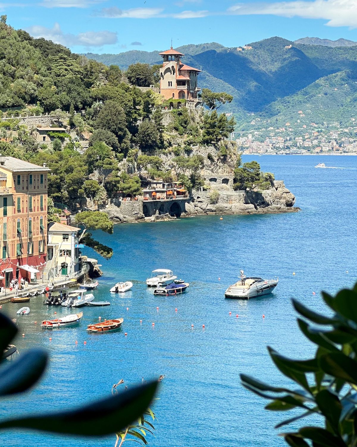 Boats docked in blue sea beside cliffs near Portofino