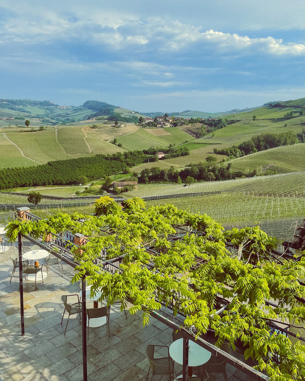 Round tables and chairs outside overlooking Barolo vineyards at Palas Cerequio hotel