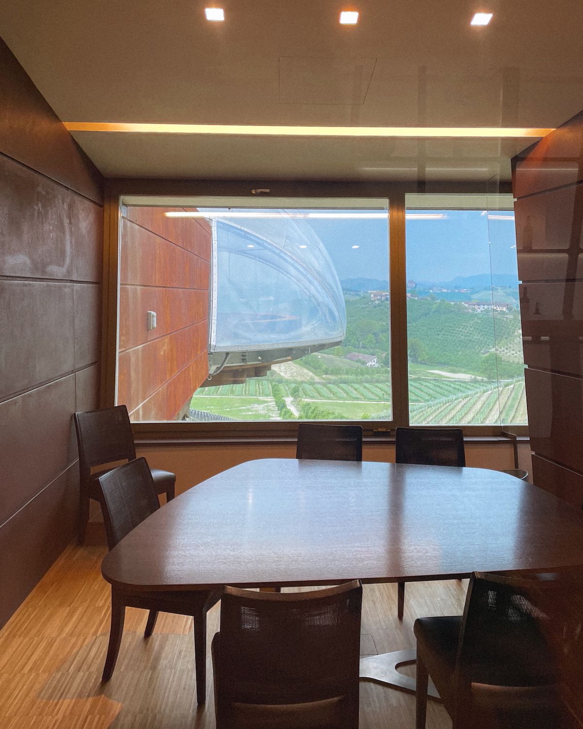 Dark wood table in a tasting room up high overlooking Barolo vineyards