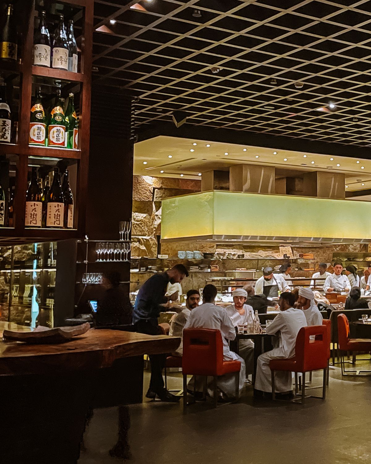 Men in white robes around a white table in Zuma Abu Dhabi