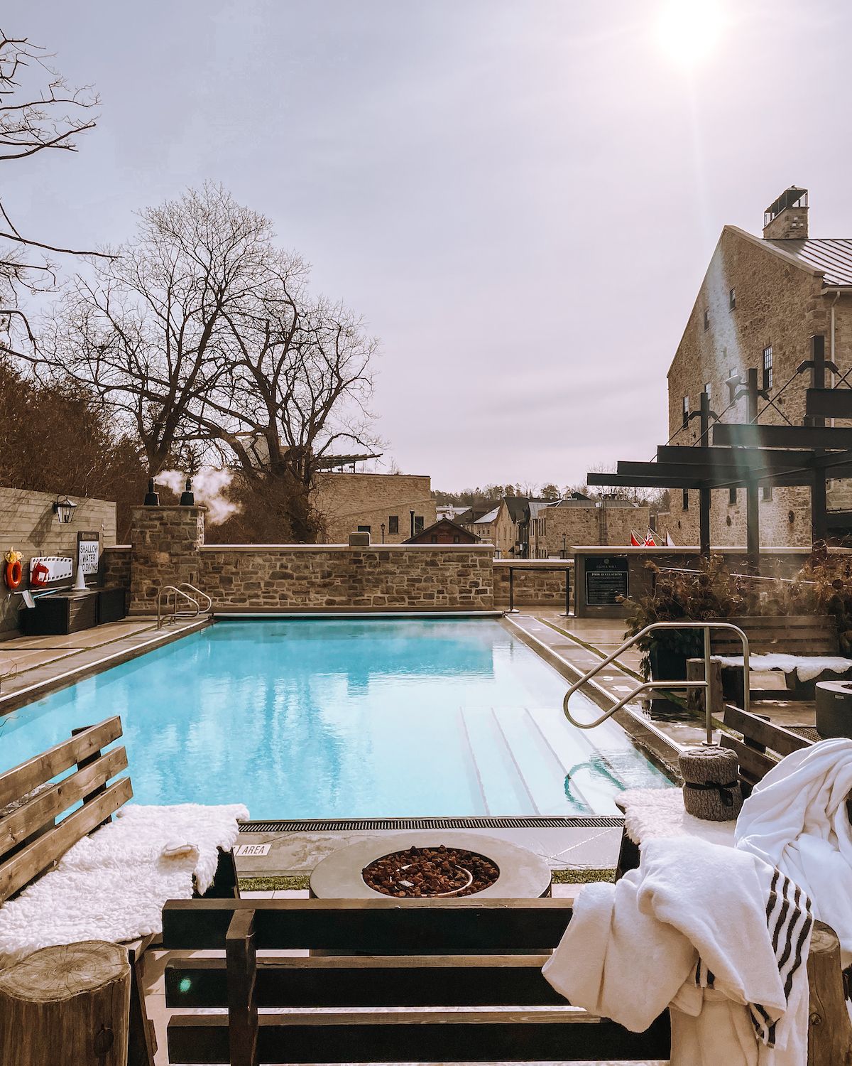 Heated outdoor pool with fire pit on a chilly winter's day at Elora Mill Hotel & Spa 