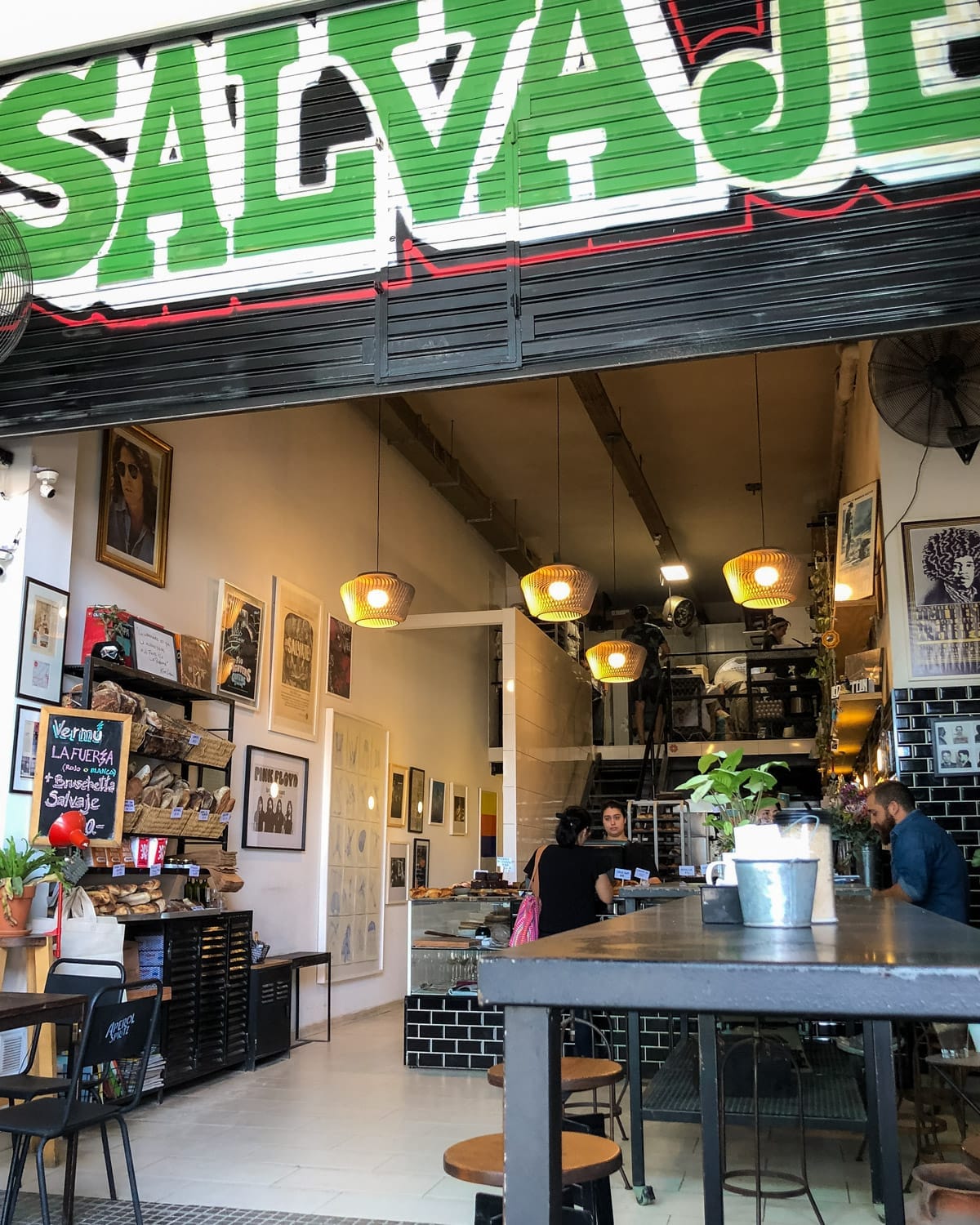 Eclectic Salvaje Bakery with black tile, warm lighting, and local art in an industrial space.