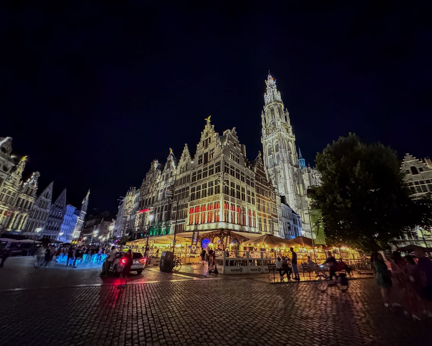 The illuminated Cathedral of Our Lady towers over the Grote Markt square.