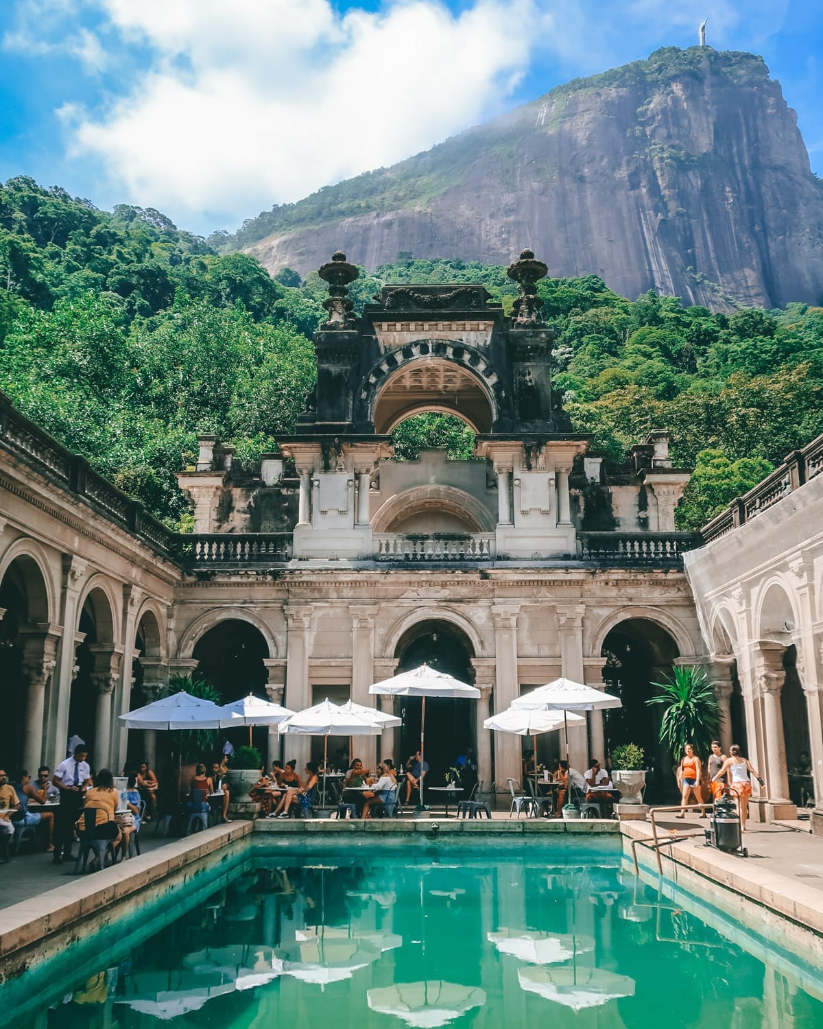 The arched courtyard and pool of Parque Lage with Christ the Redeemer on the mountain behind.