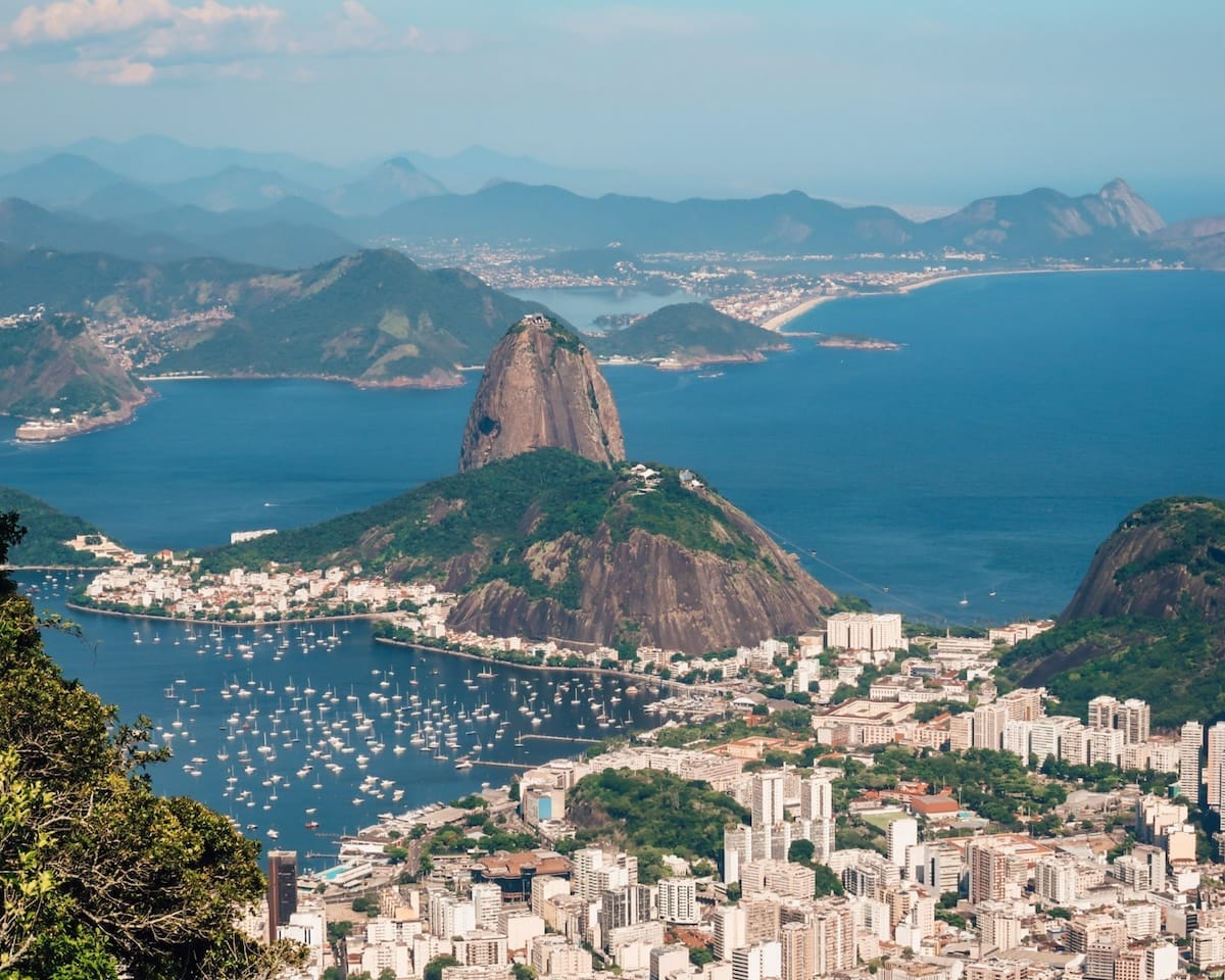 Panoramic shot of Sugarloaf Mountain and Guanabara Bay seen from atop Corcovado Mountain, a classic angle of Rio de Janeiro.