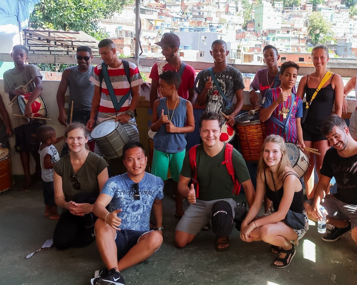 Group photo with school kids holding drums, taken after their performance in Rocinha favela.