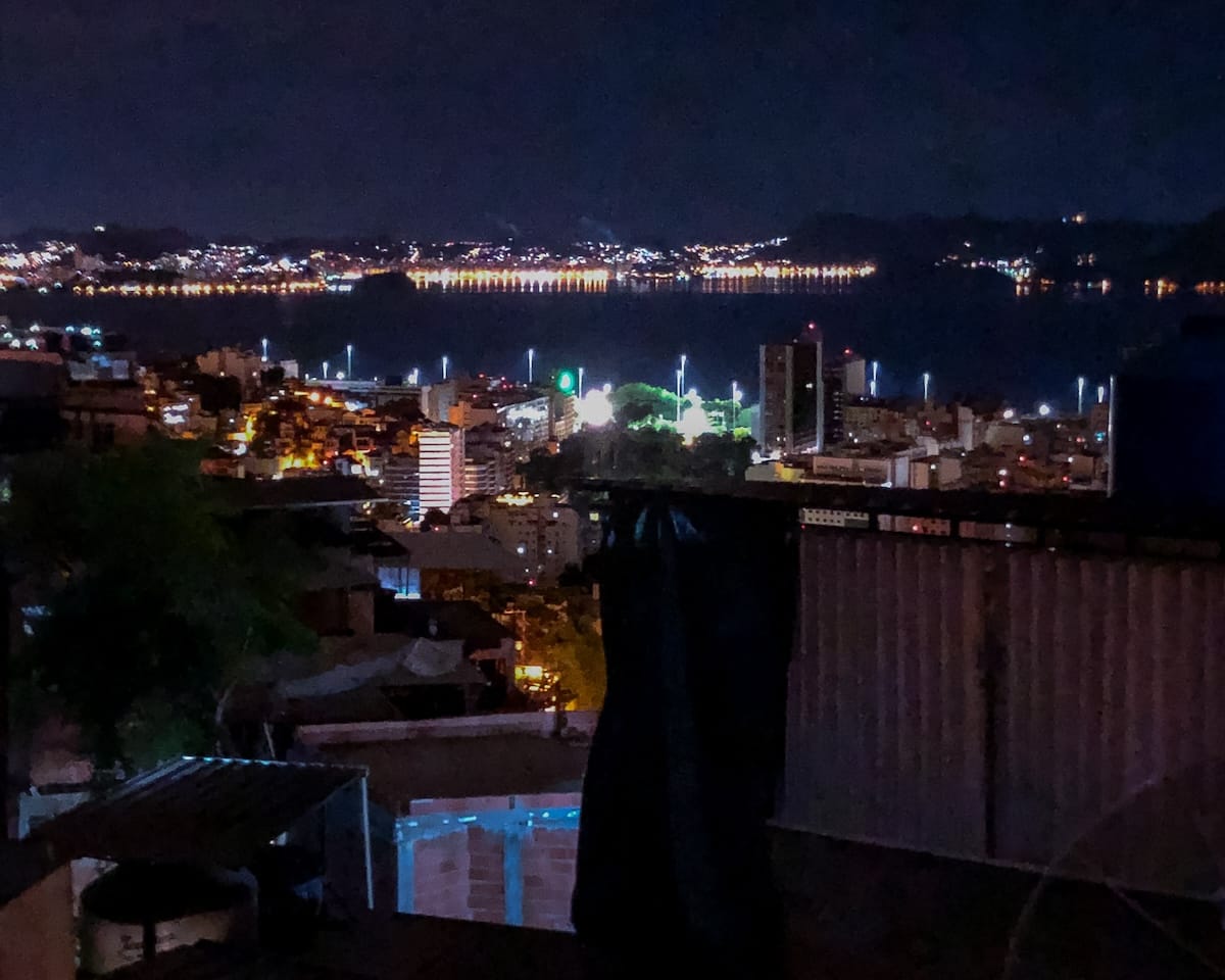 Cityscape at night viewed from The Maze, with twinkling lights across Rio and distant reflections on the bay.
