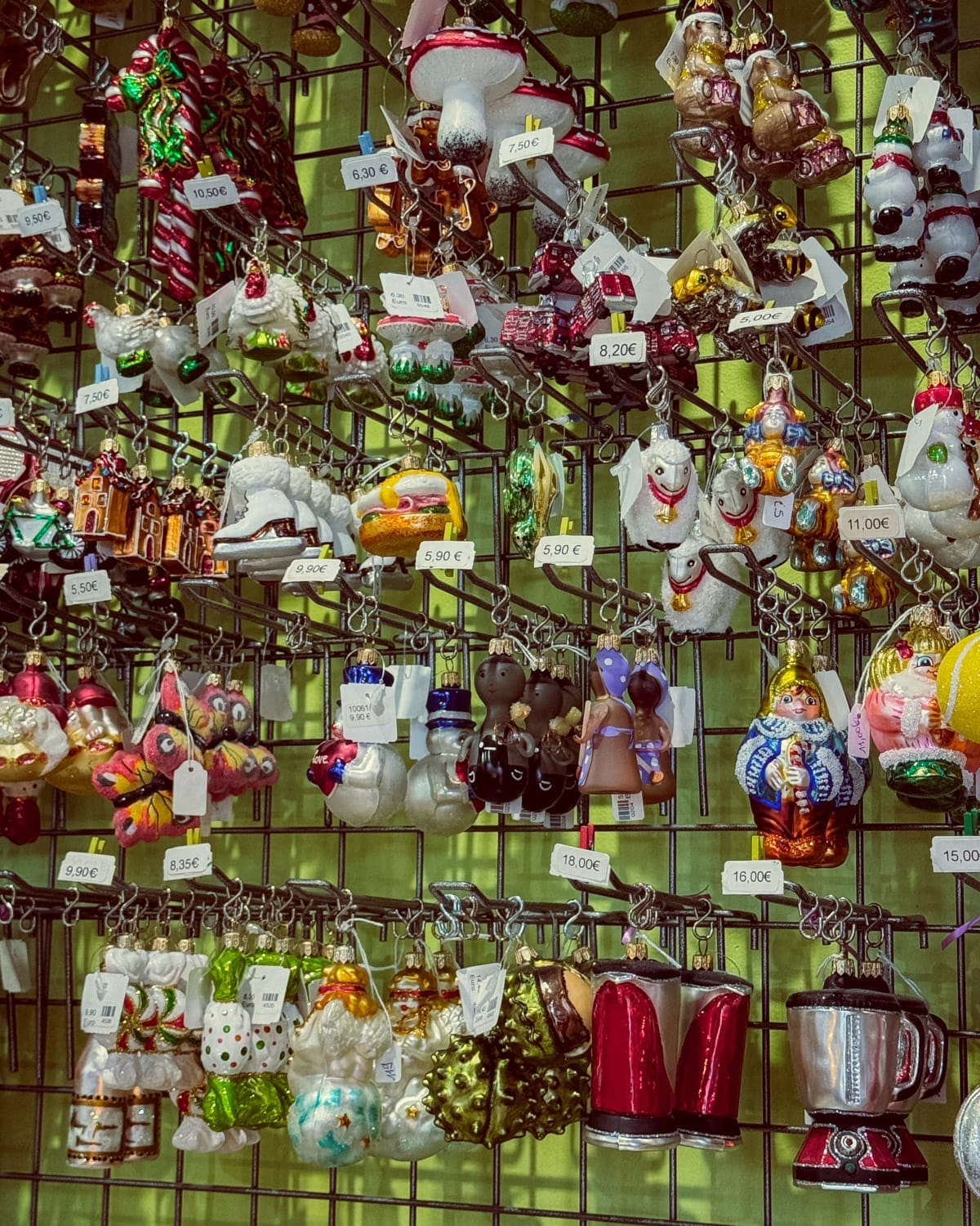 Colourful display of quirky glass ornaments hanging on a wire grid at Christel Dauwe in Antwerp.