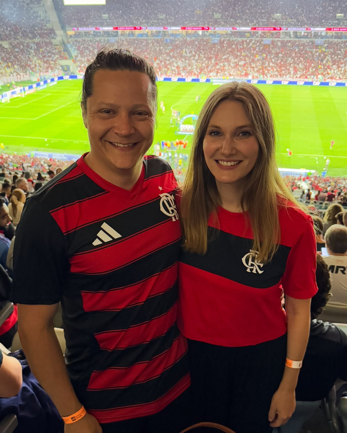 Cec and Ari wearing Flamengo jerseys at Maracanã Stadium, experiencing a thrilling local football match in Rio.