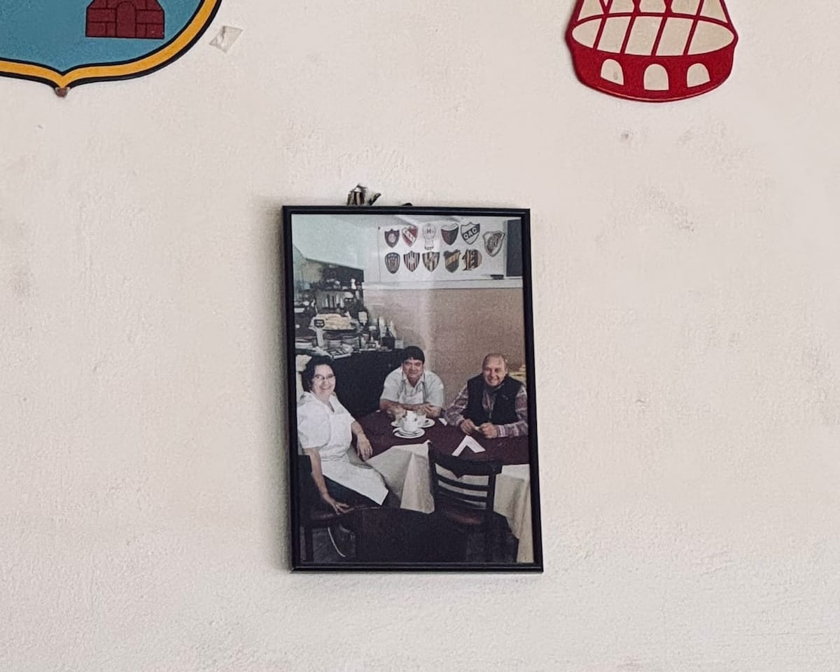 Old framed photo on a restaurant wall showing three family members at a table at Los Dos Hermanos.