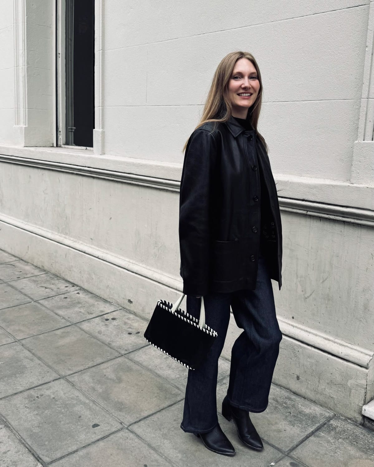 Cec in her new black leather jacket walking down a street in Buenos Aires.