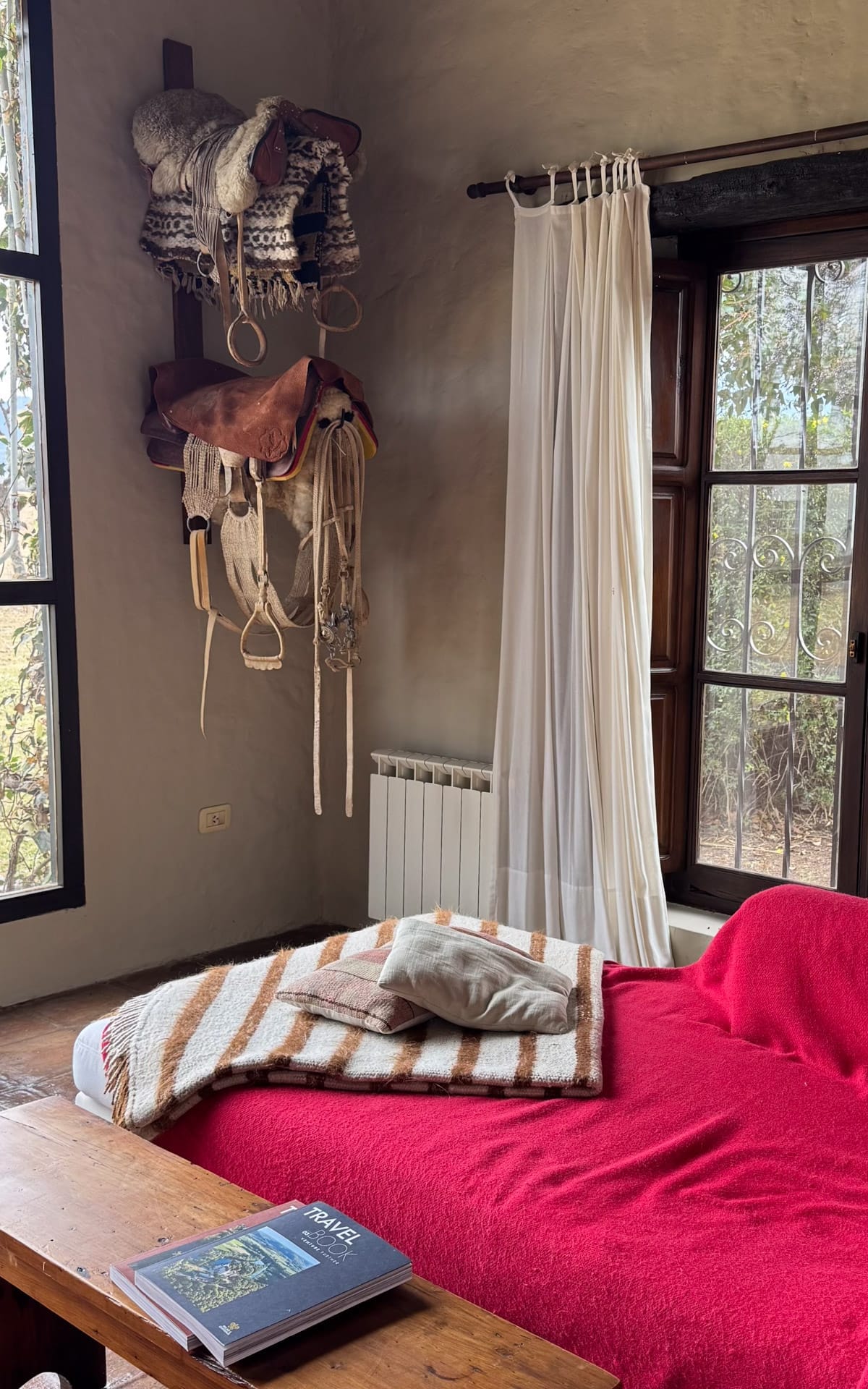Rustic-chic nook at House of Jasmines with wool blankets, horse saddles, and natural light.
