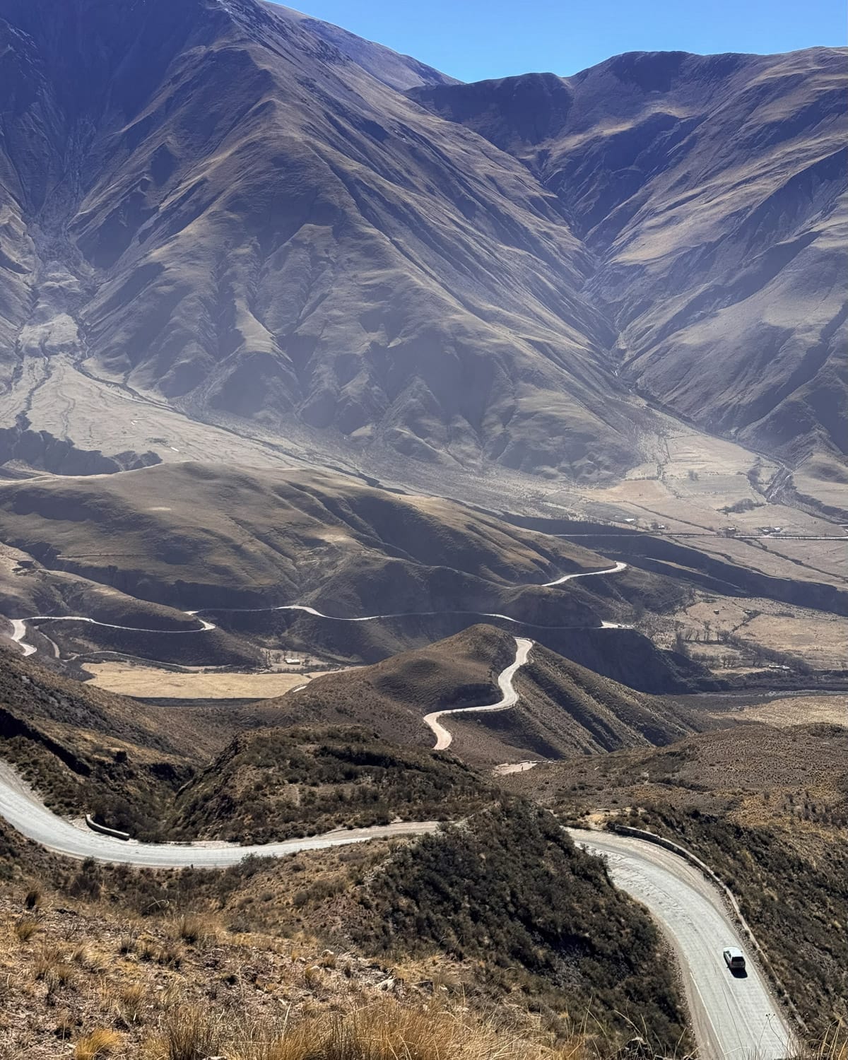 A winding mountain road cutting through steep valleys on Cuesta del Obispo, one of Salta’s most scenic drives.