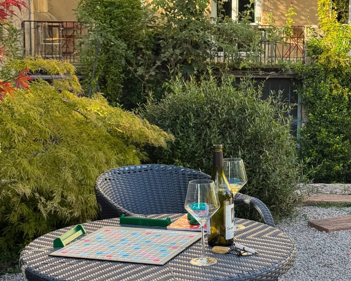 Garden table set with Jura wine and a Scrabble board at La Closerie des Capucines.