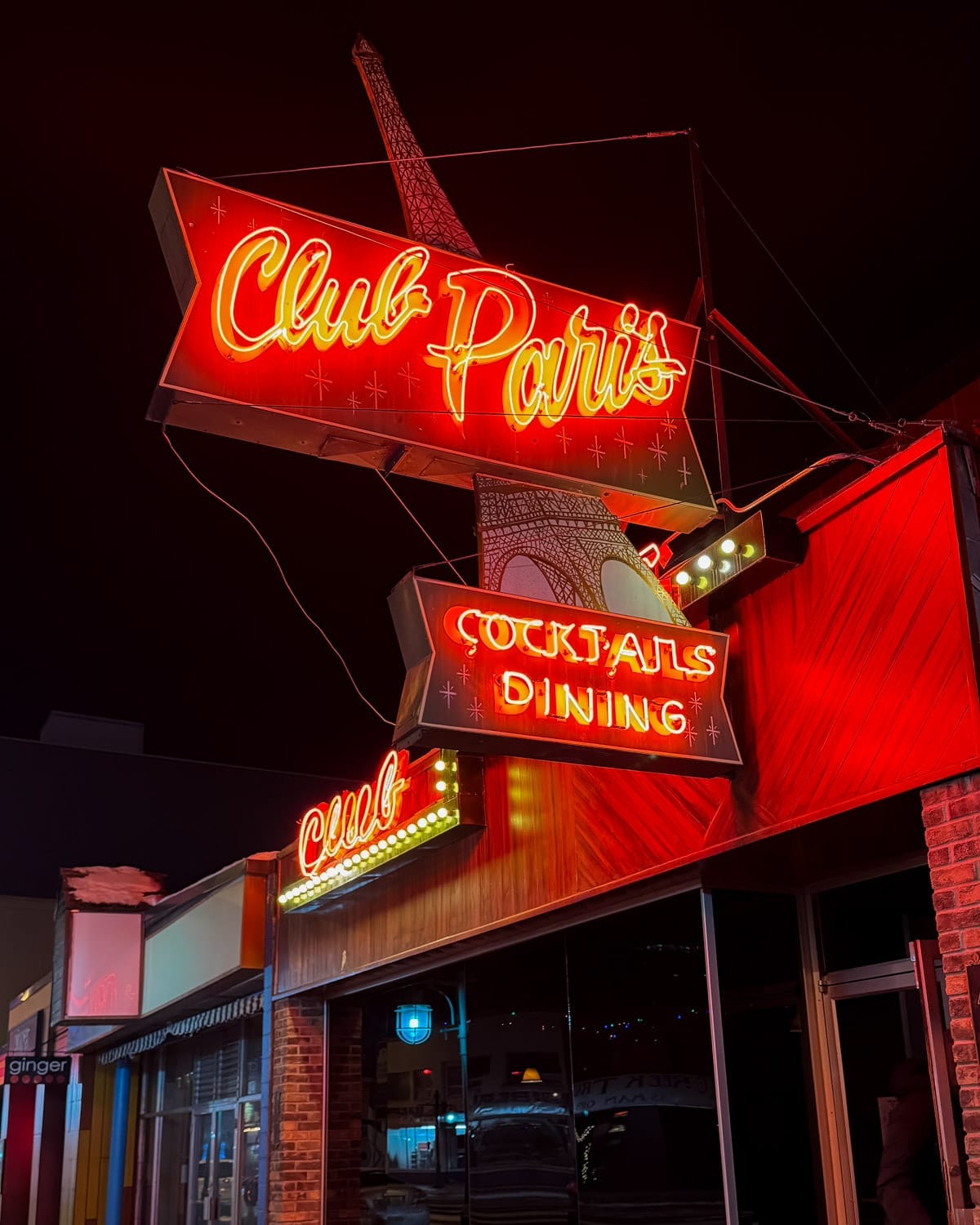Club Paris neon sign glowing red at night in downtown Anchorage.