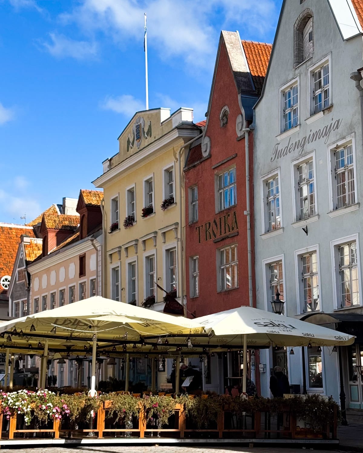 Colourful pastel merchant houses with outdoor cafe terraces in Raekoja Plats.