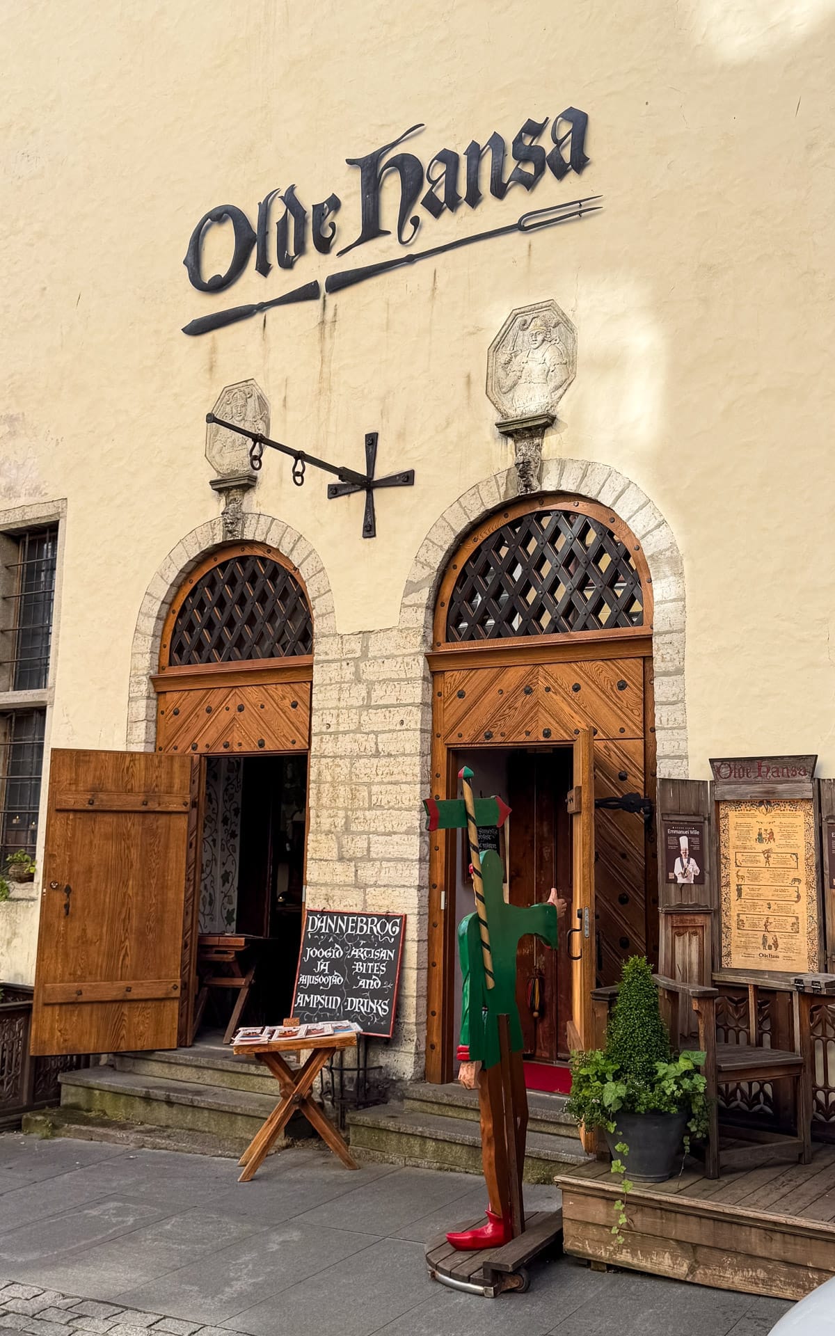 Entrance to Olde Hansa medieval restaurant in Tallinn with wooden doors and historic signage.