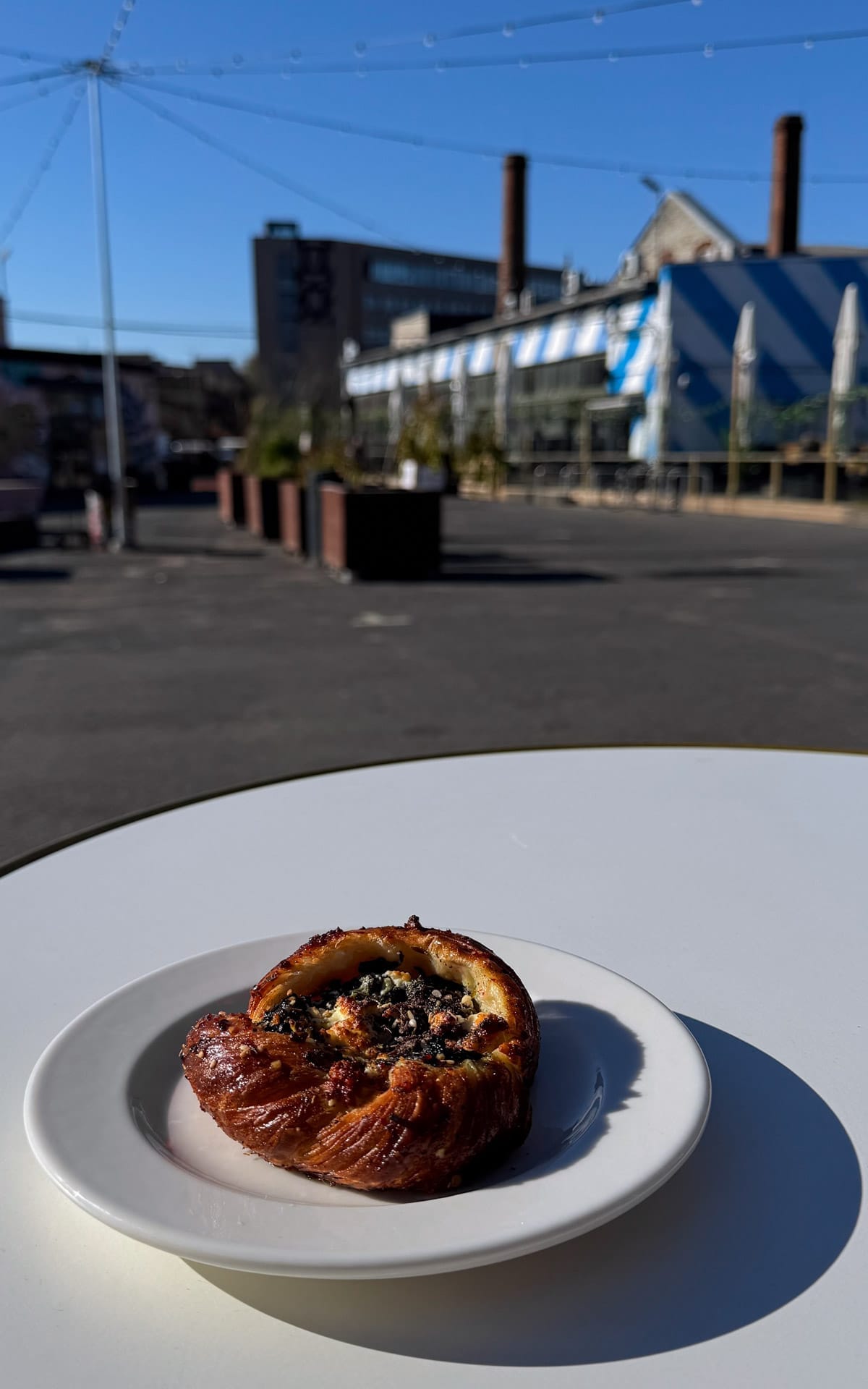 Fresh pastry on a white plate at an outdoor table at Karjase Sai in Telliskivi industrial district.