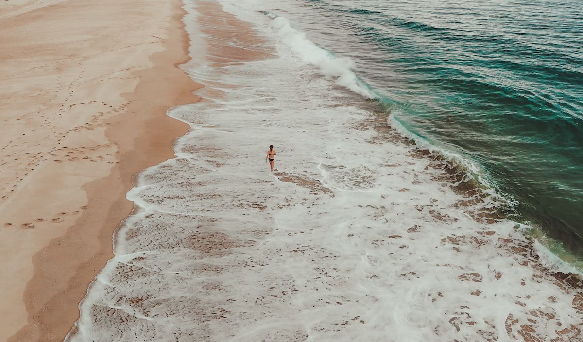 Cec walking along the long Atlantic coastline, one of the best things to do in Cap Ferret.