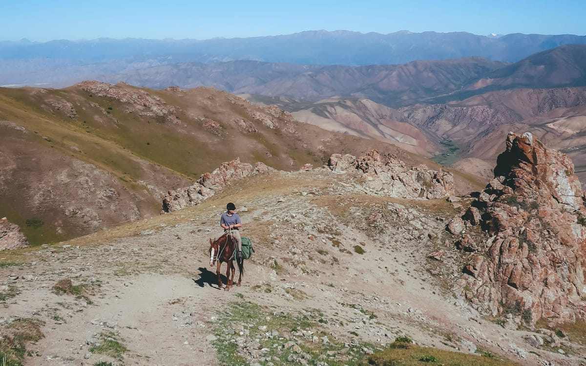 Horse trekking up a rugged mountain pass to Song Kul Lake in Kyrgyzstan, one of the best travel adventures.