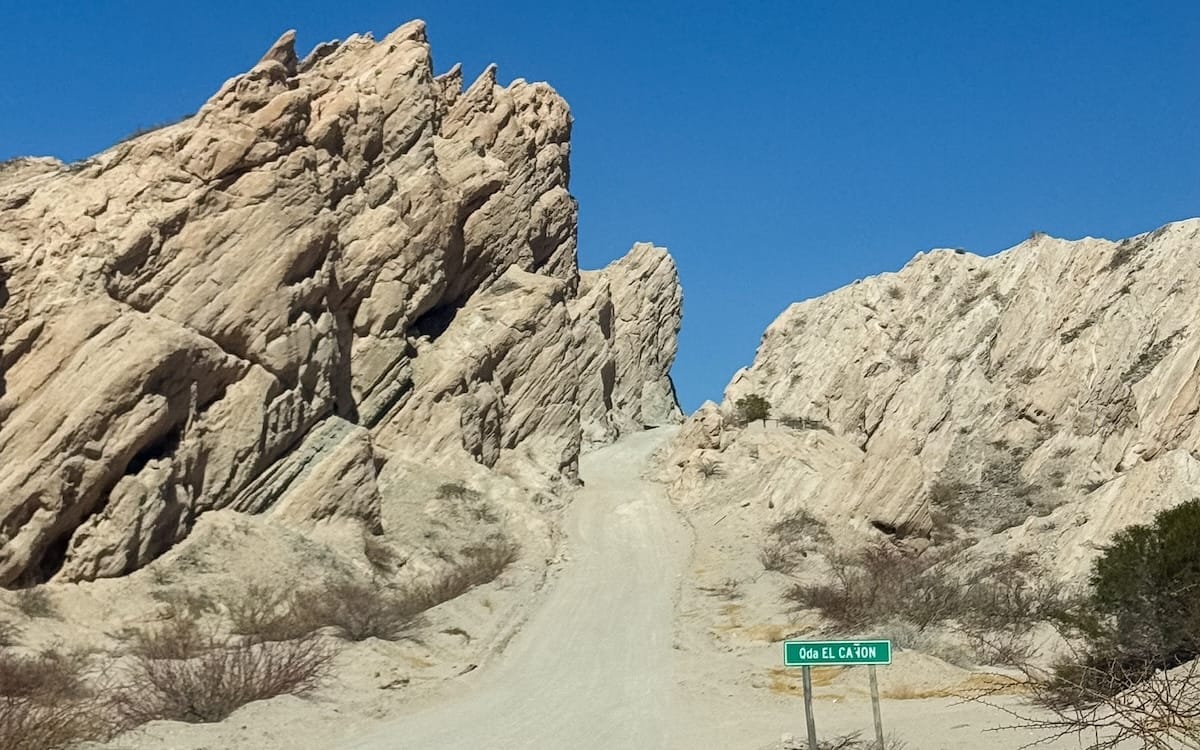 Scenic road winding through dramatic rock formations in Quebrada de las Flechas, one of the most breathtaking stops on the Salta itinerary.