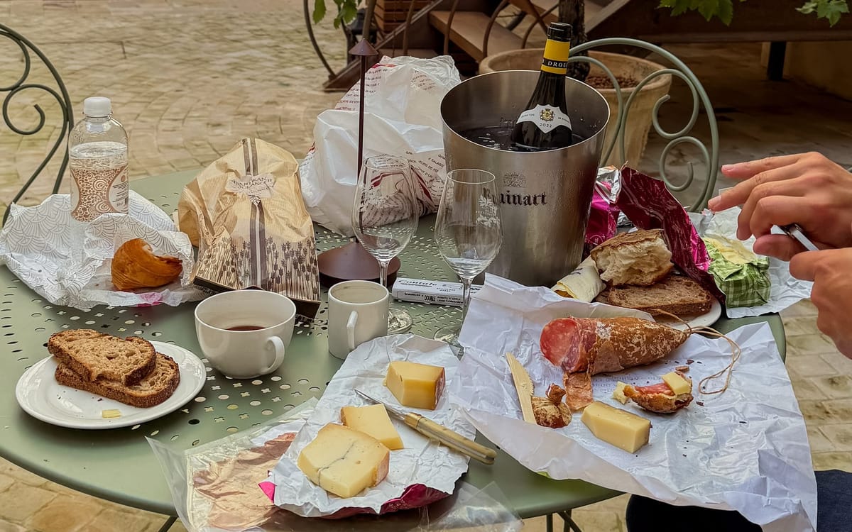 Outdoor picnic with Comté cheese, saucisson, fresh bread, and wine in Beaune, a gourmet stop along the Jura and Burgundy road trip.